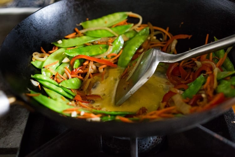 Scrambling egg in wok for Singapore noodles.