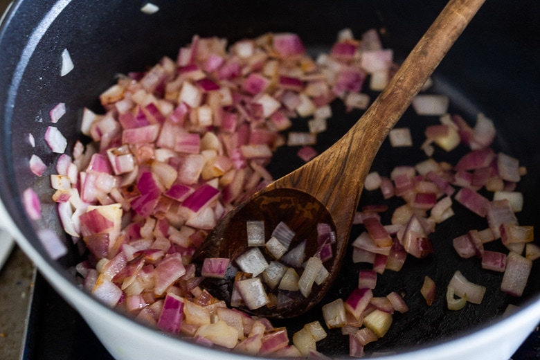 sautéed onions in pot stirred with wooden spoon.