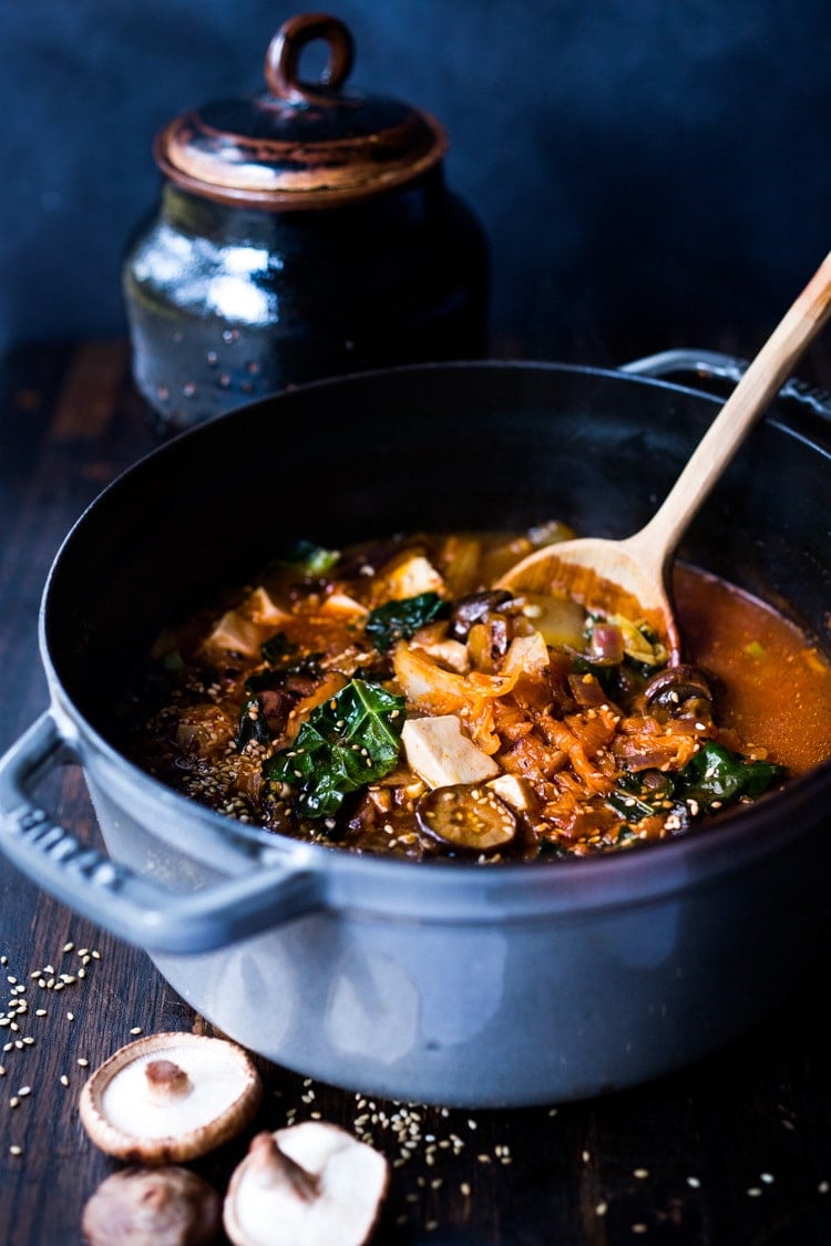 A simple easy recipe for Kimchi Soup- this version is vegan, made with shiitake mushrooms, silken tofu and kale. Serve over rice or noodles! Delicious Korean flavor! #kimchisoup #easykimchisoup #vegankimchisoup #plantbased #cleaneating #eatclean #vegansoup #koreansoup 