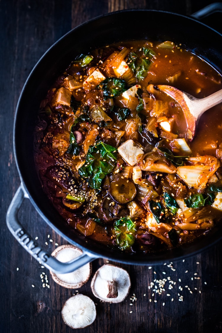 A simple easy recipe for Kimchi Soup- this version is vegan, made with shiitake mushrooms, silken tofu and kale. Serve over rice or noodles! Delicious Korean flavor! #kimchisoup #easykimchisoup #vegankimchisoup #plantbased #cleaneating #eatclean #vegansoup #koreansoup 