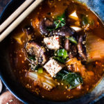 shiitake mushrooms, silken tofu and kale. Serve over rice or noodles! Delicious Korean flavor! #kimchisoup #easykimchisoup #vegankimchisoup #plantbased #cleaneating #eatclean #vegansoup #koreansoup