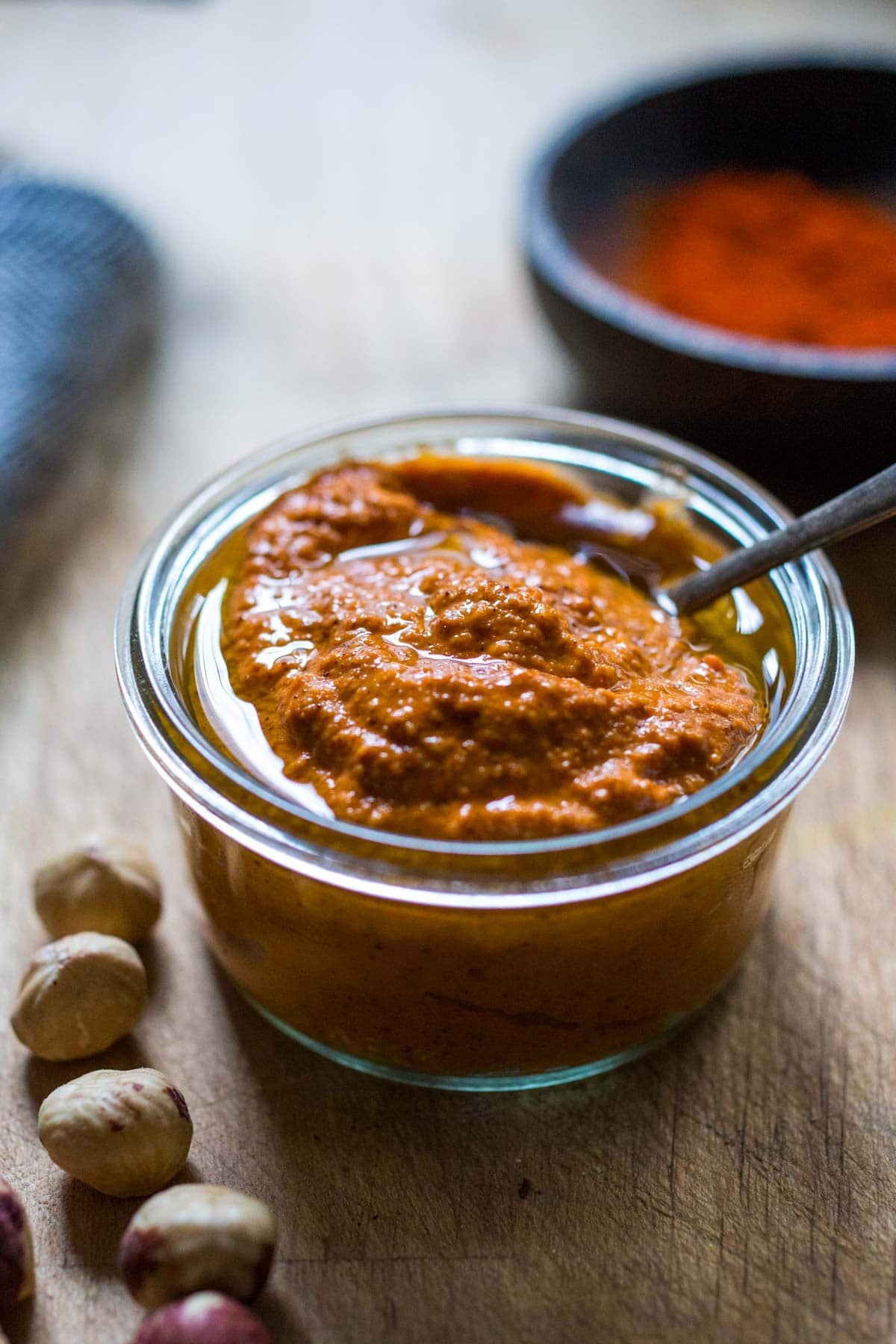 romesco sauce in a bowl with chili flakes and fresh herbs.