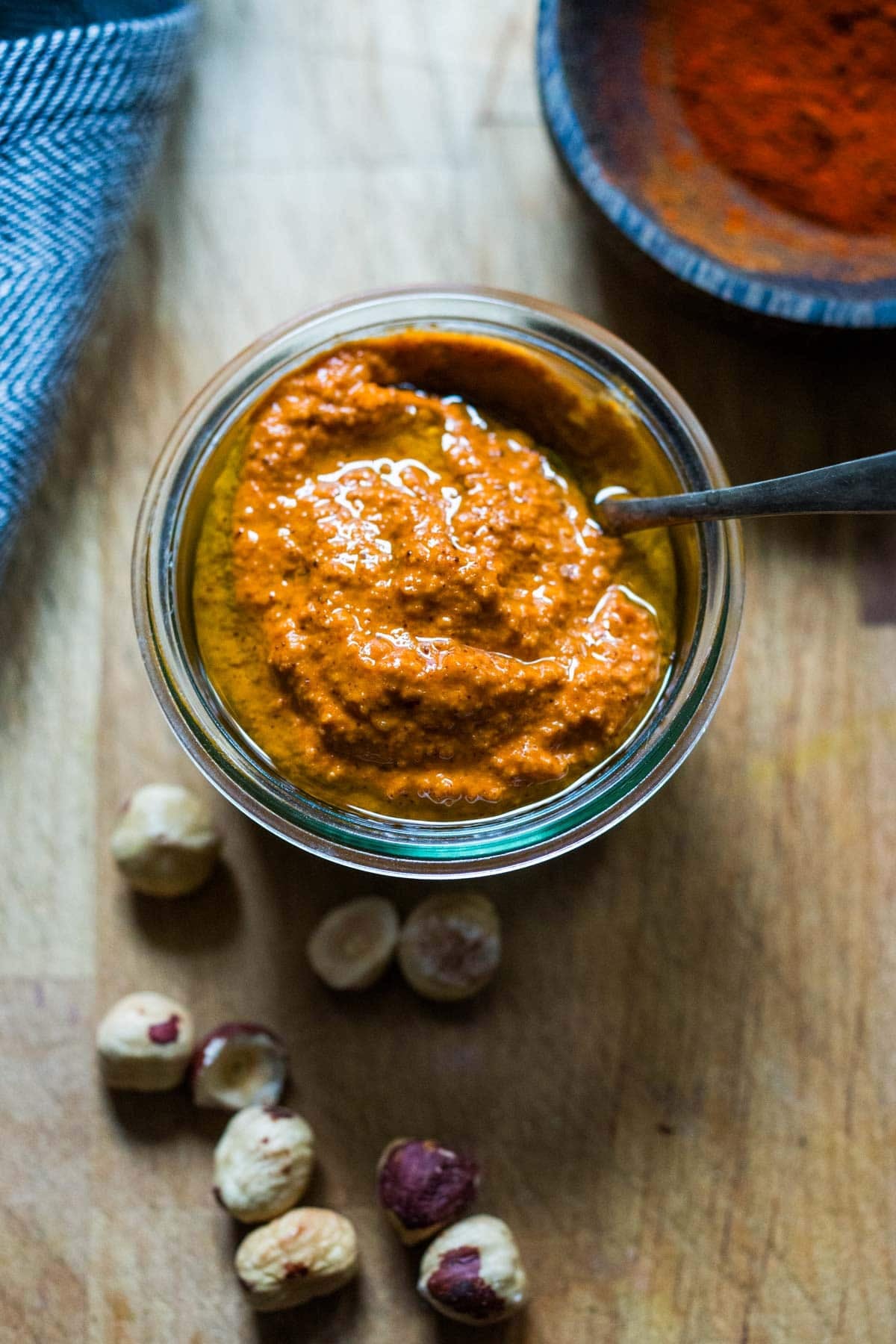 romesco sauce in a bowl with chili flakes and fresh herbs.