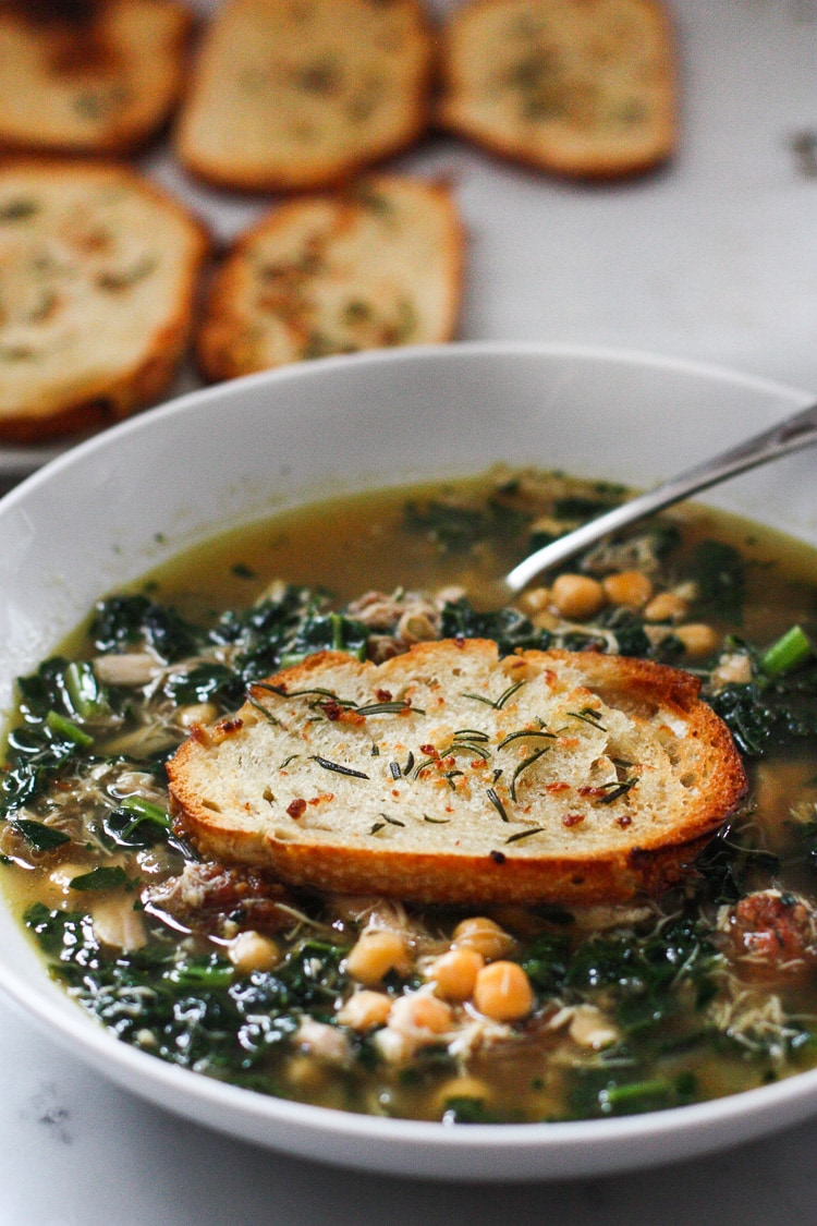 Kale, Chickpea and Chicken soup with a toasty rosemary crouton. Simple and delicious. #chickensoup #kale #chickpeasoup | www.feastingathome.com