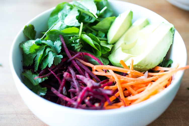 Vegan collard greens wraps are filled with hummus, crispy tofu, shredded beets, carrots and avocado! Drizzle with Tahini sauce! A delicious healthy lunch! #eatclean #cleaneating #vegan #veganlunch #rainbowwrap #Wraps #veganwrap #plantbased #collardgreens