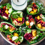 Vegan collard greens wraps are filled with hummus, crispy tofu, shredded beets, carrots and avocado! Drizzle with Tahini sauce! A delicious healthy lunch! #eatclean #cleaneating #vegan #veganlunch #rainbowwrap #Wraps #veganwrap #plantbased #collardgreens