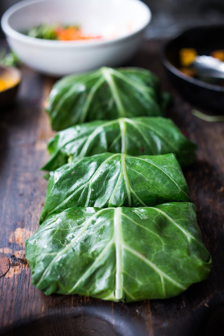 Rainbow Wraps! This vegan collard greens wraps are filled with hummus, crispy tofu, shredded beets, carrots and avocado! Drizzle with Tahini sauce! A delicious healthy lunch! #eatclean #cleaneating #vegan #veganlunch #rainbowwrap #Wraps #veganwrap #plantbased #collardgreens