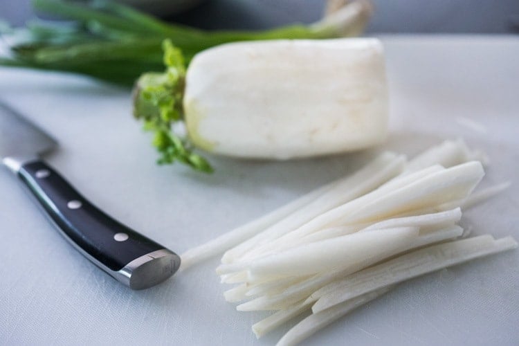 slicing the daikon radish into matchsticks.