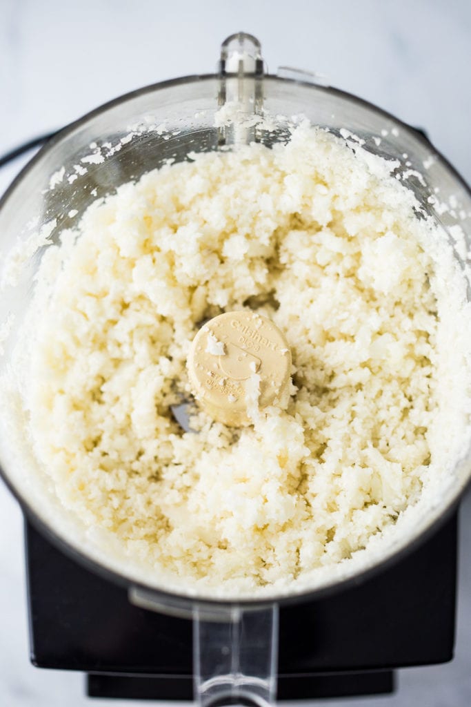 shredded cauliflower rice in bowl of food processor.