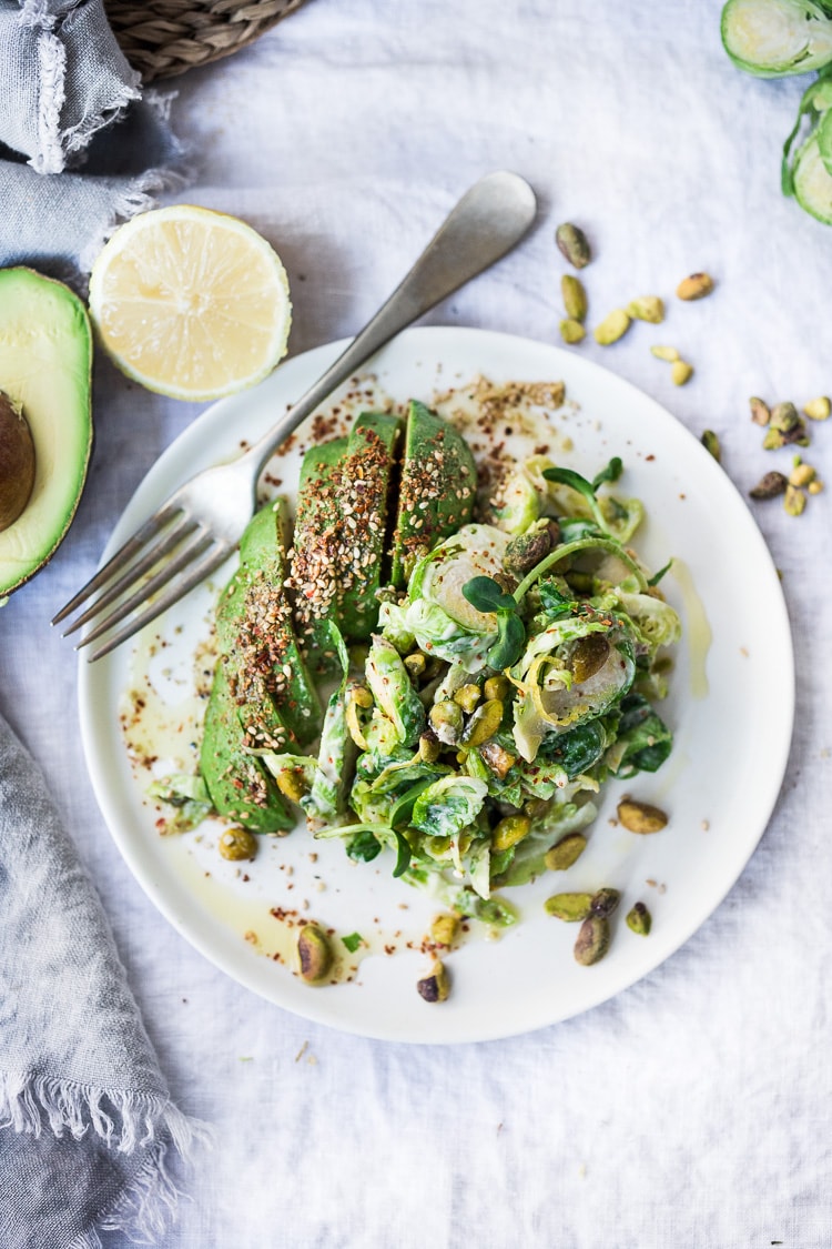 Lemony Brussel Sprout Salad with Creamy Tahini Sauce and Pistachios - a tasty, vegan salad that can be made ahead. Perfect for midweek lunches or potlucks or gatherings. #brusselsprouts #brusselsproutsalad #brusselsproutslaw #brusselsproutsrecipes #vegan #plantbased #cleaneating #eatclean #vegansalad 