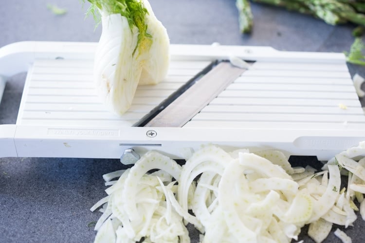 Shaved fennel on a mandoline for asparagus salad.