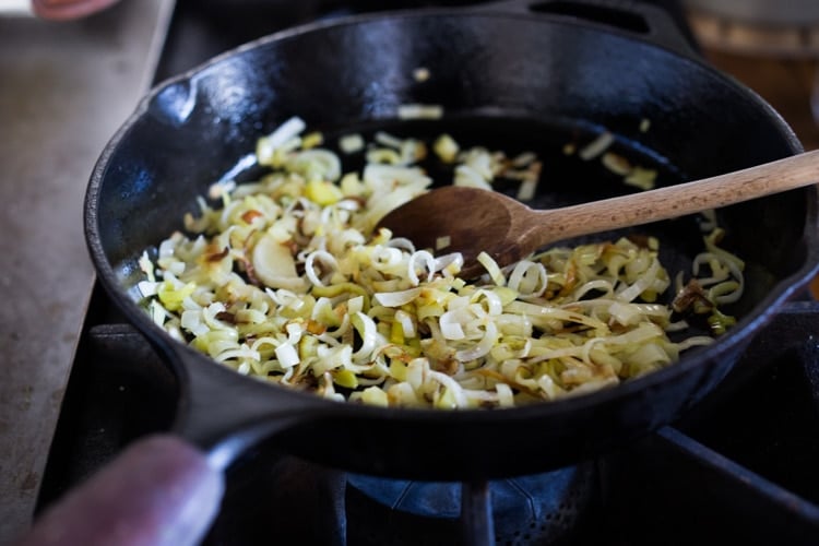 Leeks sautéed in a pan for asparagus salad.