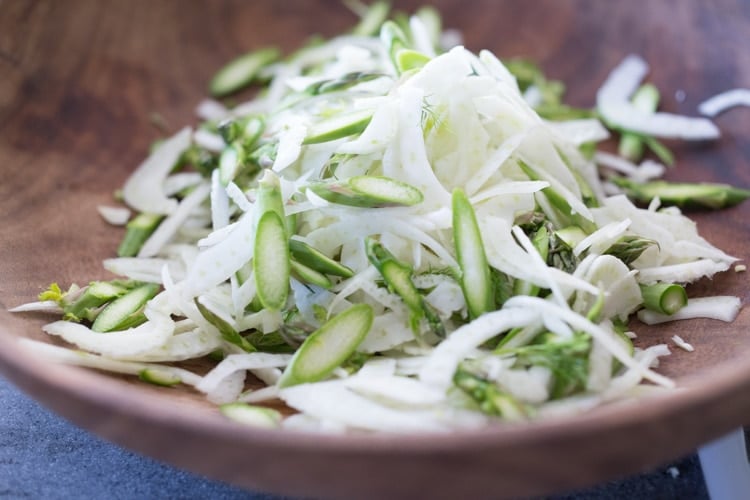 Fennel and asparagus in a wooden bowl making asparagus salad.