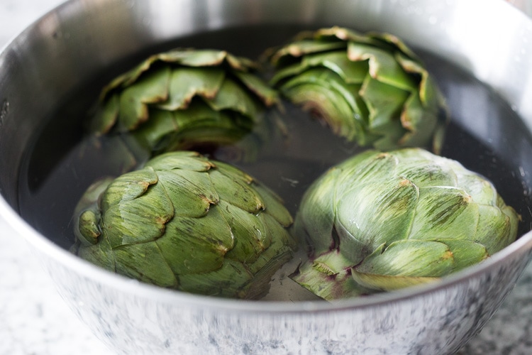 How to roast Artichokes! Roasted Artichokes with Lemony Leek dressing - a healthy vegan way to cook and serve our favorite spring vegetable! #artichoke #artichokes #bakedartichokes #roastedartichokes #vegan #veganartichokesauce 