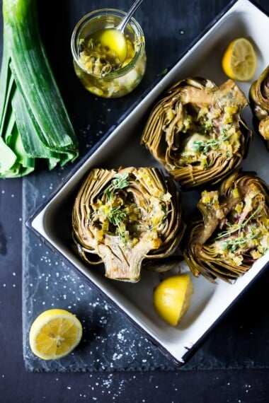Roasted Artichokes with Lemony Leek dressing - a healthy vegan way to cook and serve our favorite spring vegetable! #artichoke #artichokes #bakedartichokes #roastedartichokes #vegan #veganartichokesauce