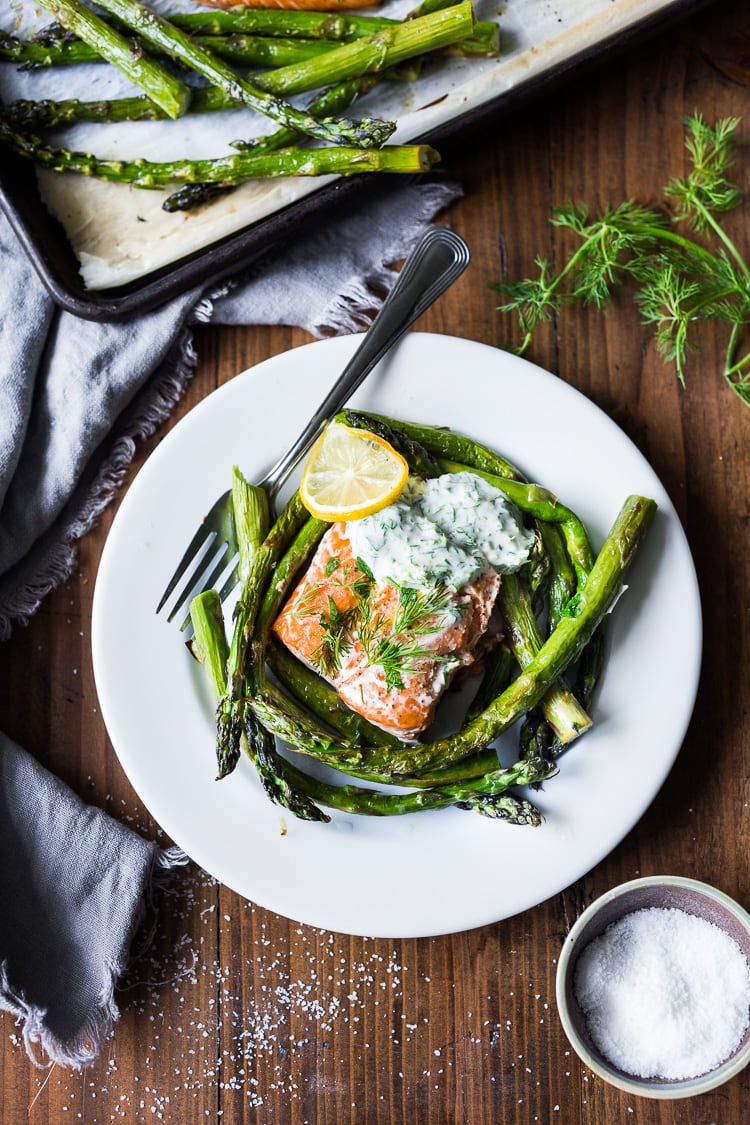 Simple Baked Salmon with Asparagus and Yogurt Dill Sauce - an EASY healthy, sheet-pan dinner that comes together in under 30 minutes. #salmon #roastedsalmon #bakedsalmon #aspargus #dinner #sheetpandinner #easyrecipes #healthy #keto #lowcarb 