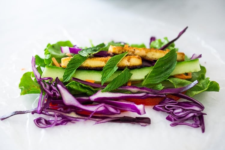 rice paper wrapper with veggies and baked tofu piled in center.