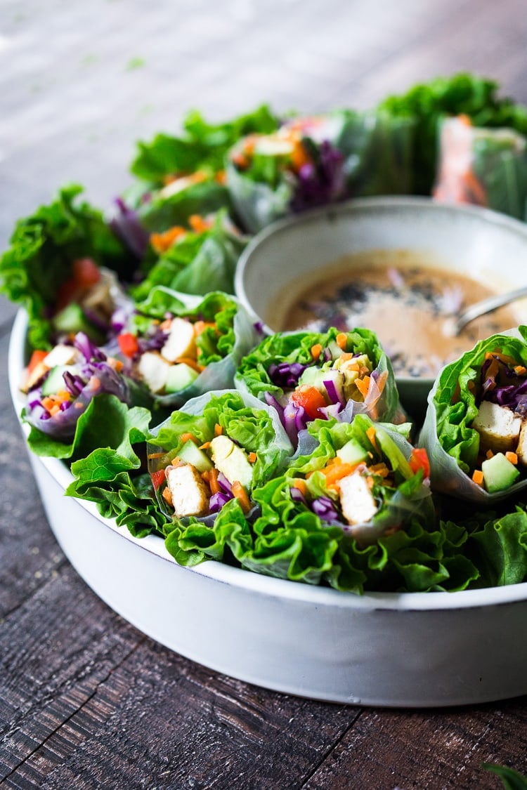 How to make fresh Spring Rolls with BEST EVER Peanut Sauce! These vegan spring rolls can made ahead and stored for healthy lunches or potlucks and gatherings. #springrolls #veganspringrolls #freshspringrolls #howtostorespringrolls #howtomakespringrolls