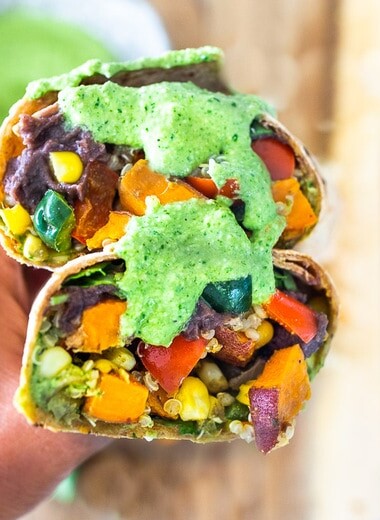 These Vegan Peruvian Burritos are filled with roasted sweet potato, fresh corn, peppers, quinoa and creamy blackbeans, then drizzled with spicy Peruvian Green Sauce. A flavor bomb! Vegan and Delicious! #vegan #burrito #peruvianfood #peruvianrecipes #veganburrito