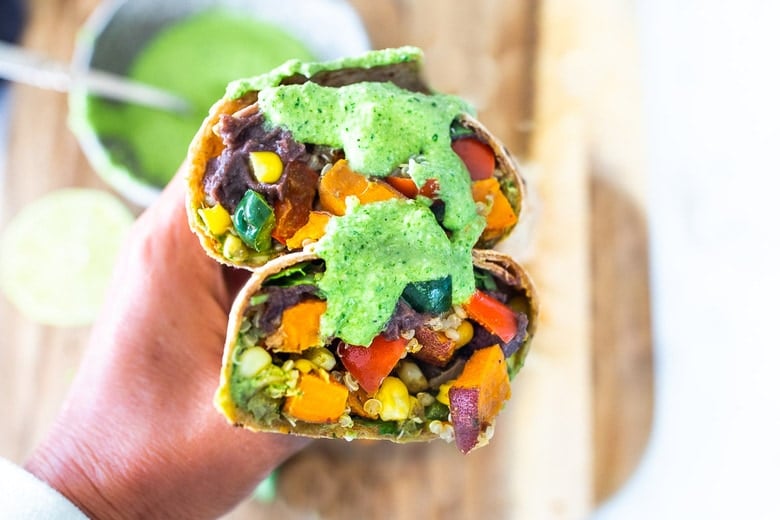 These Vegan Peruvian Burritos are filled with roasted sweet potato, fresh corn, peppers, quinoa and creamy blackbeans, then drizzled with spicy Peruvian Green Sauce. A flavor bomb! Vegan and Delicious! #vegan #burrito #peruvianfood #peruvianrecipes #veganburrito 