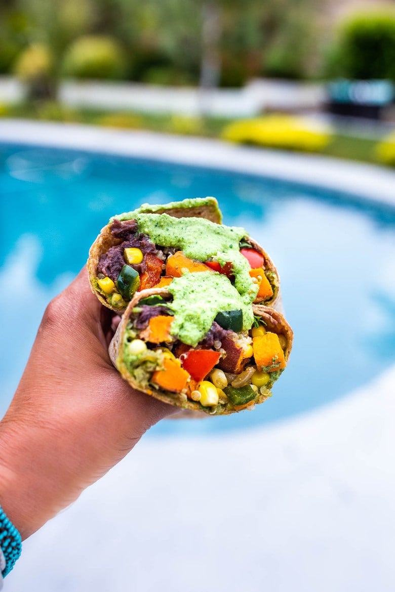 These Vegan Peruvian Burritos are filled with roasted sweet potato, fresh corn, peppers, quinoa and creamy blackbeans, then drizzled with spicy Peruvian Green Sauce. A flavor bomb! Vegan and Delicious! #vegan #burrito #peruvianfood #peruvianrecipes #veganburrito 