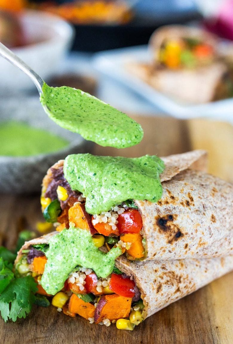 These Peruvian Burritos are filled with roasted sweet potato, fresh corn, peppers, quinoa and creamy blackbeans, then drizzled with spicy Peruvian Green Sauce. A flavor bomb! Vegan and Delicious! #vegan #burrito #peruvianfood #peruvianrecipes #veganburrito