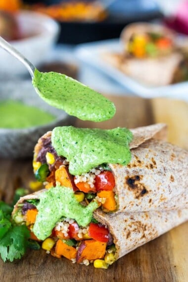 These Peruvian Burritos are filled with roasted sweet potato, fresh corn, peppers, quinoa and creamy blackbeans, then drizzled with spicy Peruvian Green Sauce. A flavor bomb! Vegan and Delicious! #vegan #burrito #peruvianfood #peruvianrecipes #veganburrito
