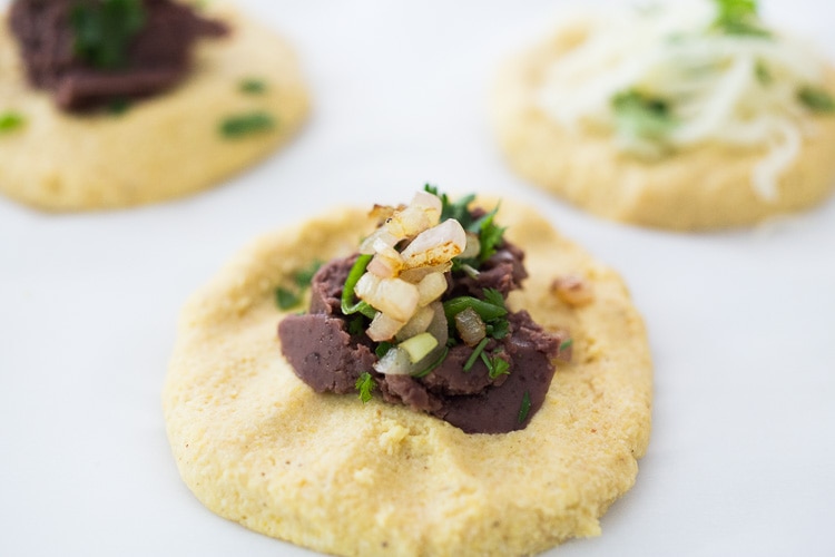 How to make Pupusas!  Delicious Salvadorian masa corn cakes filled with your choice of refried beans or cheese (or both!) with cilantro and scallions. A simple, easy recipe that is Vegan adaptable! #pupusa #pupusas #pupusarecipe #curtido #corncakes #masa #masacakes