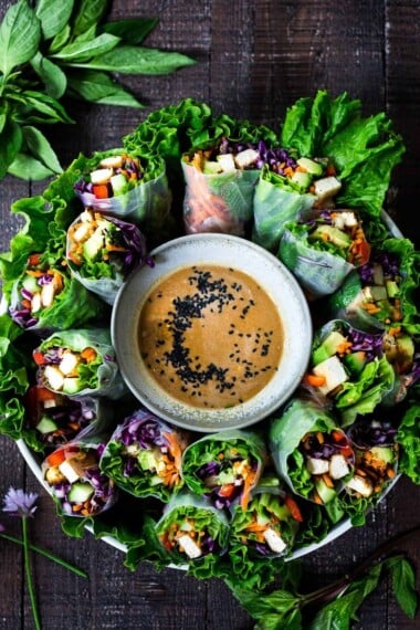 How to make fresh Spring Rolls with BEST EVER Peanut Sauce! These VEGAN spring rolls can made ahead and stored for healthy lunches or potlucks and gatherings. #springrolls #veganspringrolls #freshspringrolls #howtostorespringrolls #howtomakespringrolls