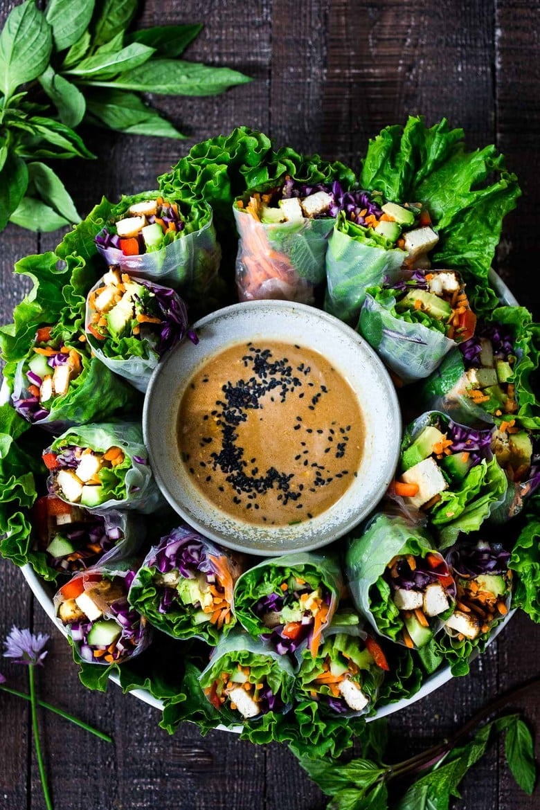 How to make fresh Spring Rolls with BEST EVER Peanut Sauce! These VEGAN spring rolls can made ahead and stored for healthy lunches or potlucks and gatherings. #springrolls #veganspringrolls #freshspringrolls #howtostorespringrolls #howtomakespringrolls