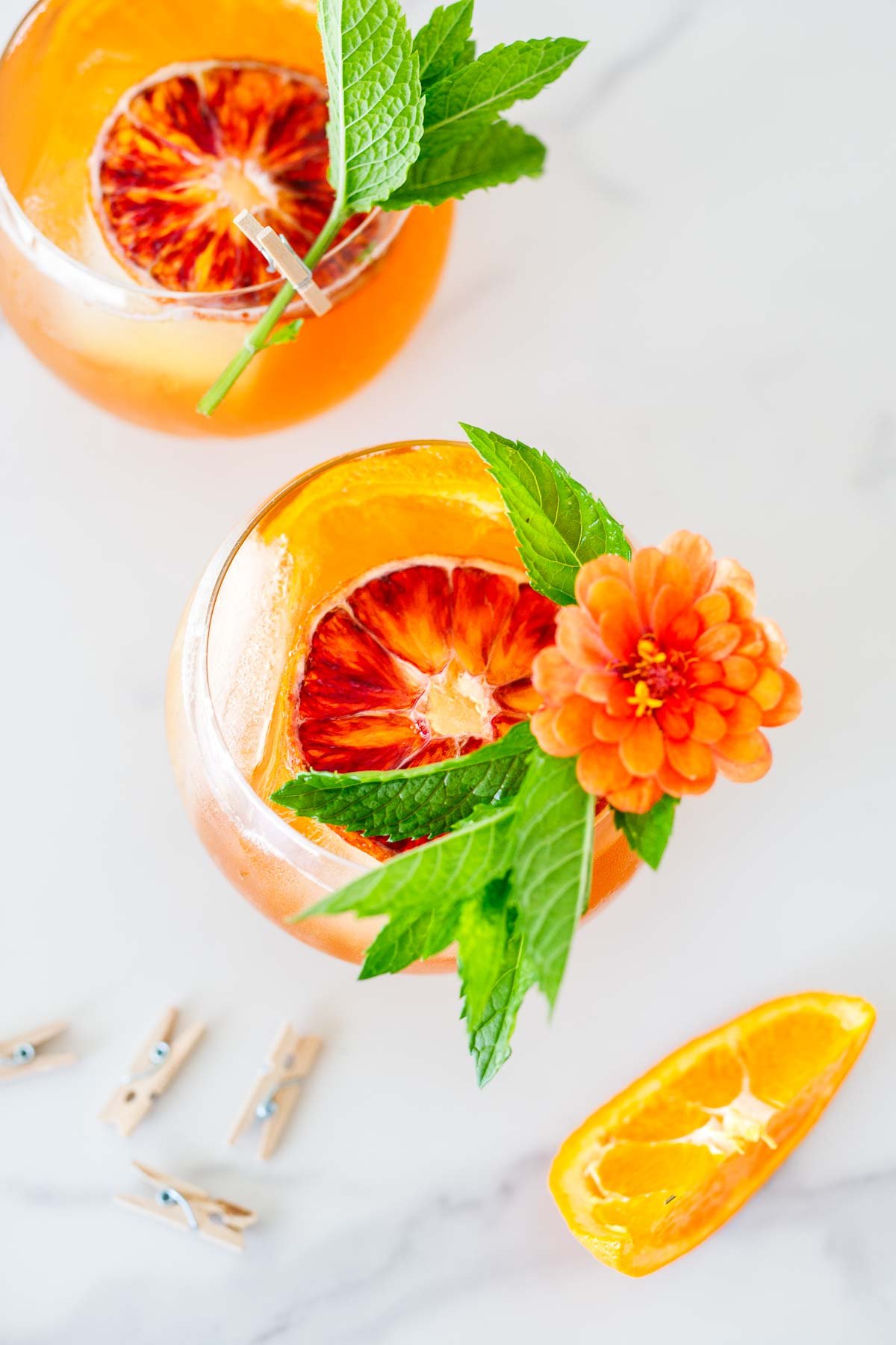 Top down view of Aperol Spritz with mint and flowers.