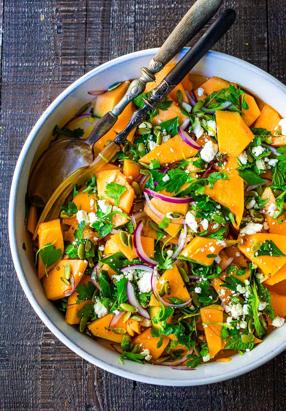 A refreshing Cantaloupe Salad with mint, lime, and pepitas with optional crumbled feta cheese- a tasty, healthy summer salad, perfect for potlucks and gatherings.