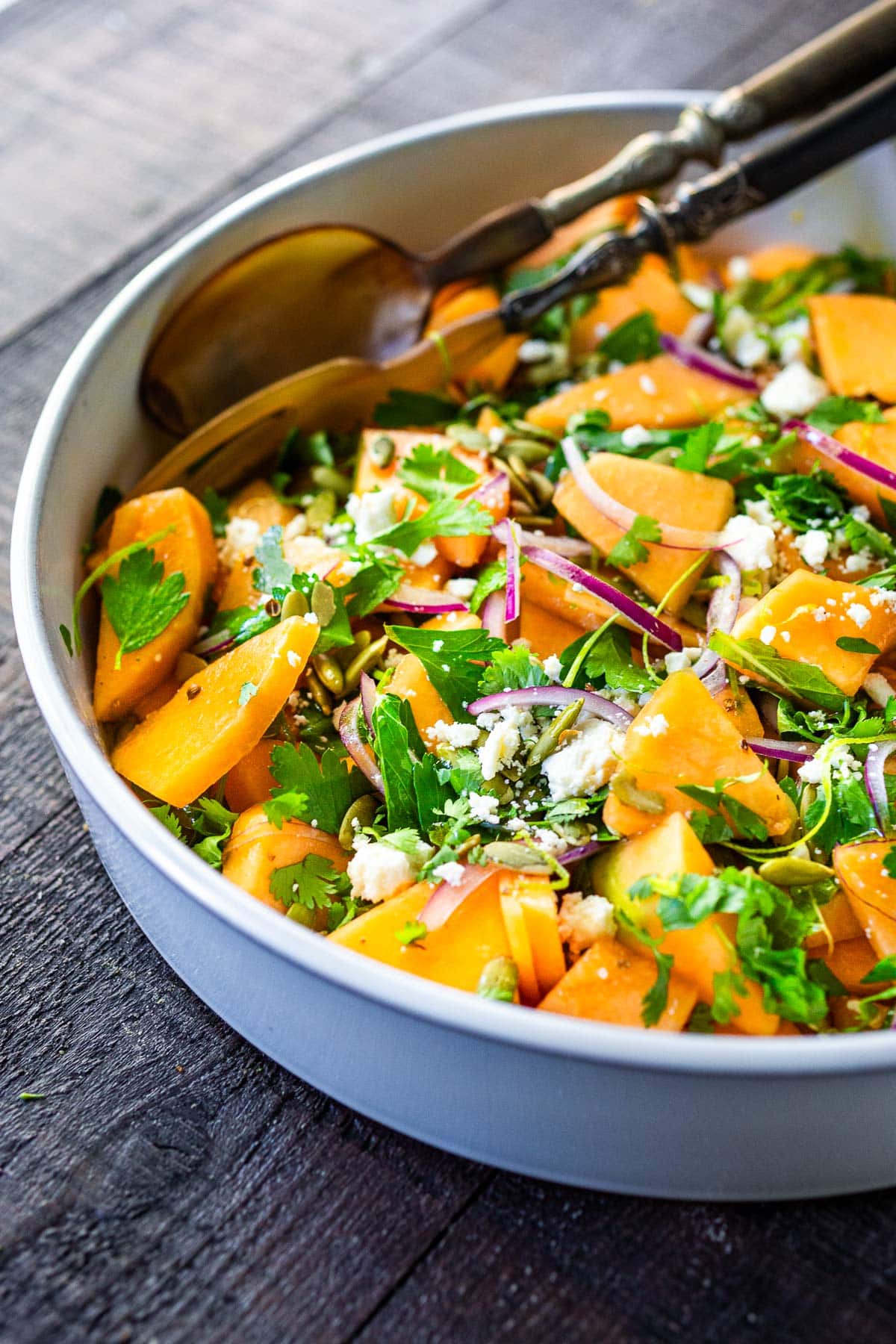 A refreshing Cantaloupe Salad with mint, lime, and pepitas with optional crumbled feta cheese- a tasty, healthy summer salad, perfect for potlucks and gatherings.