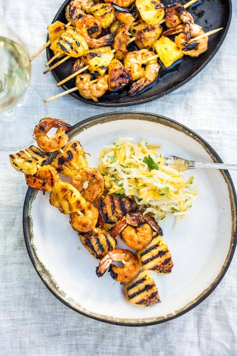 Grilled Shrimp Skewers with Pineapple in a flavorful Chipotle Marinade served with a refreshing Jicama Mango Slaw with cilantro and lime. Healthy and Easy! #grilledshrimp #shrimpskewers #shrimpkabobs #skewers www.feastingathome.com