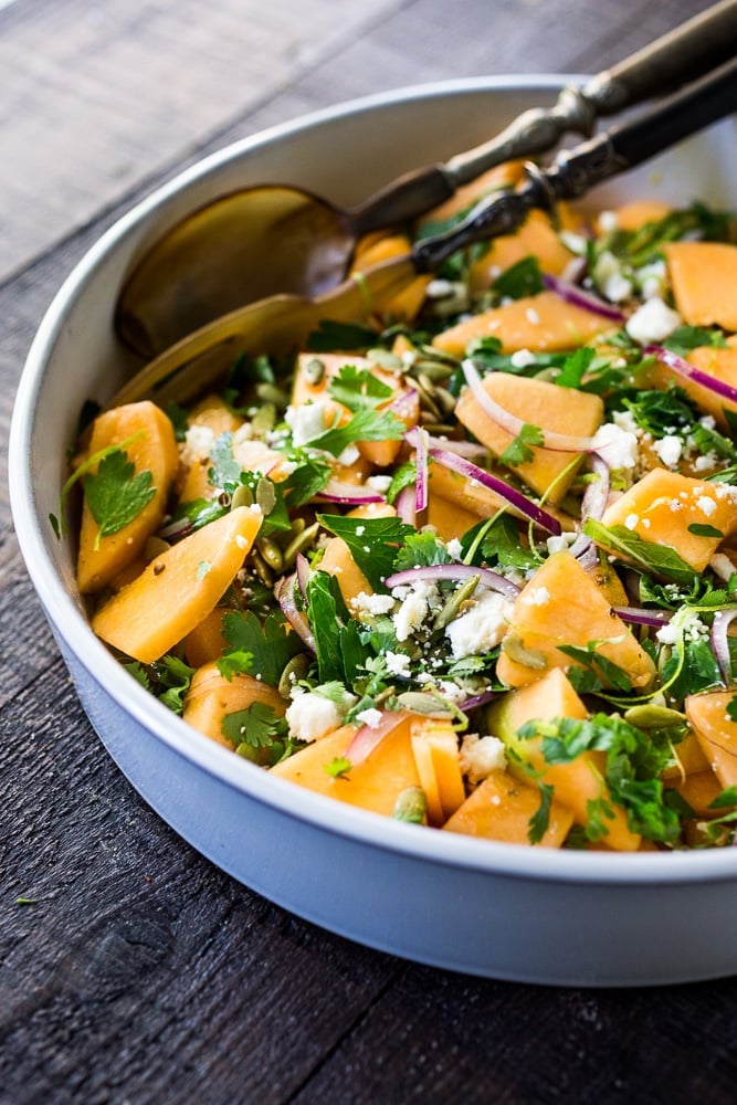 A refreshing Cantaloupe Salad with red onion, lime, cilantro, mint, Aleppo chili flakes, pepitas and optional crumbled feta (optional) - an easy healthy summer salad, perfect for potlucks and gatherings. Vegan adaptable! #cantaloupe #cantaloupesalad 