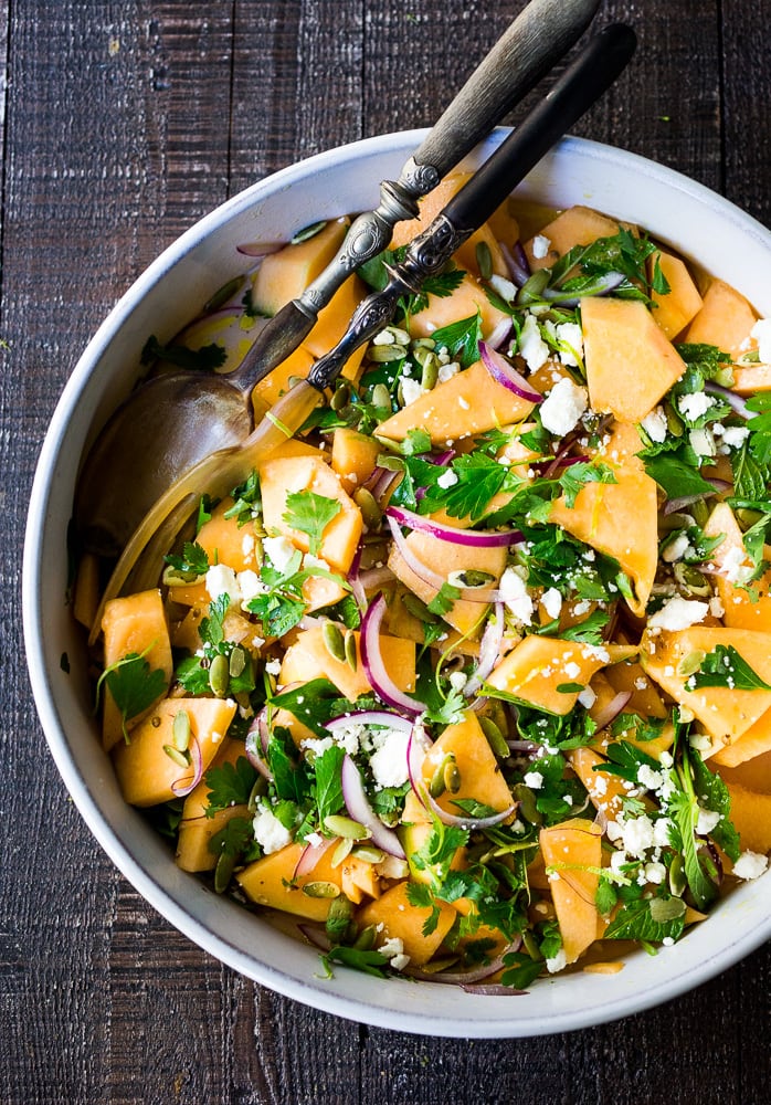 A refreshing Cantaloupe Salad with red onion, lime, cilantro, mint, Aleppo chili flakes, pepitas and optional crumbled feta (optional) - an easy healthy summer salad, perfect for potlucks and gatherings. Vegan adaptable! #cantaloupe #cantaloupesalad