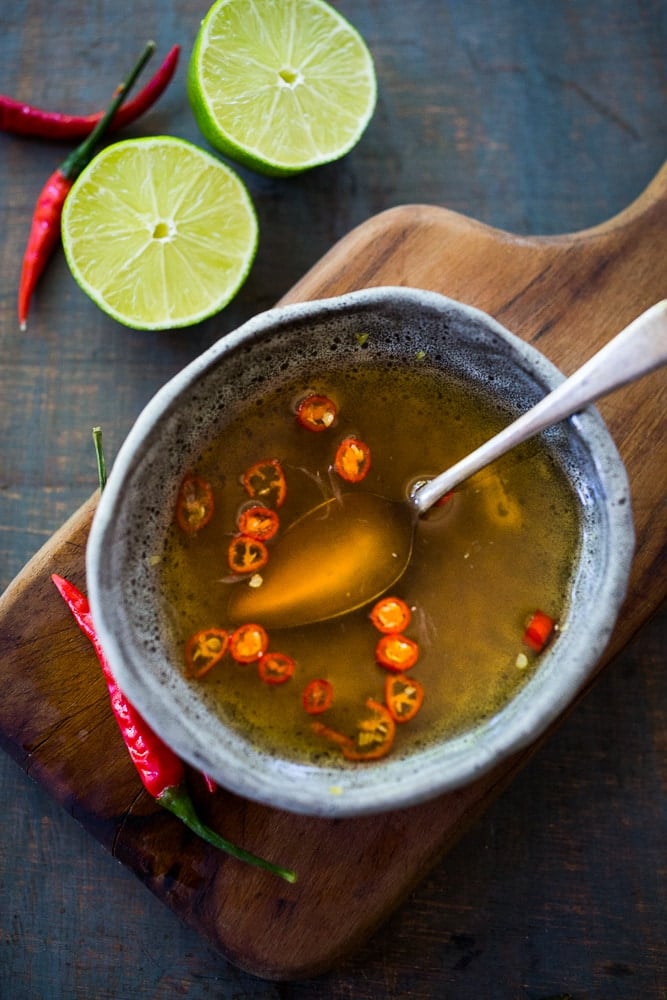 nuoc cham is small bowl with spoon and sliced red chilies. 