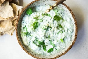 Authentic Tzatziki Sauce - a healthy, flavorful Greek cucumber-yogurt sauce to use in wraps and gyros, or as a dip for pita, or as a delicious side to Mediterranean dishes. This simple EASY recipe can be made in 15 minutes! #tzatziki #tzatzikirecipe #tzatzikisauce #easy #cucumbersalad