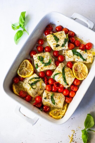 Simple Baked Cod with Tomatoes, Basil, Garlic Lemon- a fast and easy weeknight dinner that is healthy and delicious! #bakedcod #bakedfish #keto #keporecipes #weeknightdinner #weeknightdinners #easyfishrecipes