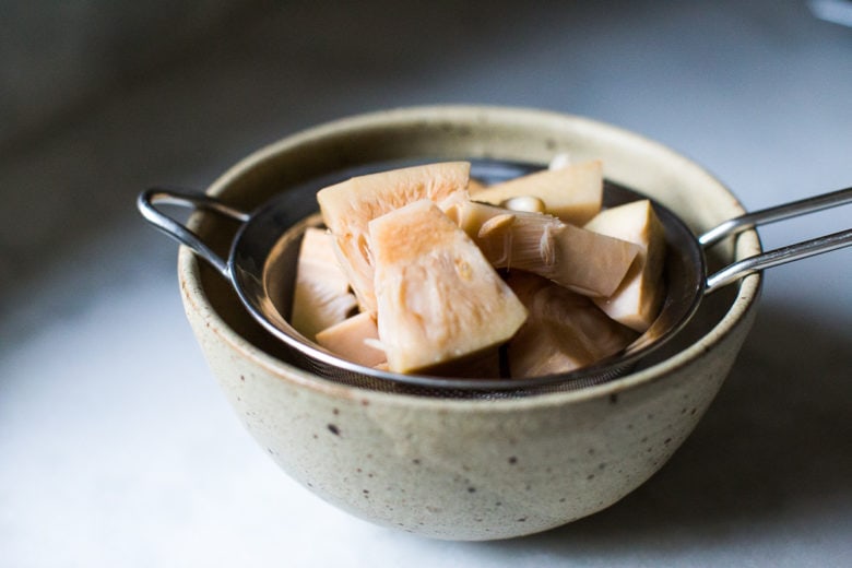 Crispy Jackfruit Carnitas- jackfruit in a colander over a bowl.