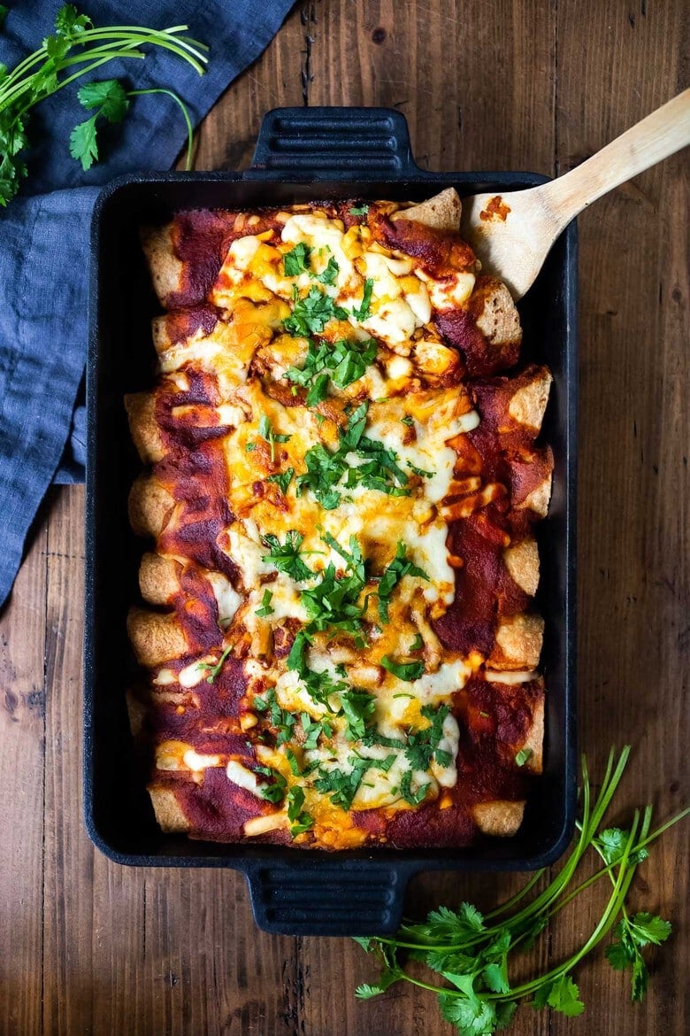 Simple Vegetarian Enchiladas- with black beans and your choice of veggies (like red bell pepper, zucchini and corn)and Homemade 5 Minute Enchilada Sauce! Easy, Healthy and full of delicious Mexican Flavor- a potluck recipe favorite! Vegan and Gluten-free adaptable! #enchiladas #vegetarianenchiladas #healthyenchiladas #veggieenchiladas