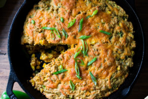 Zucchini Cornbread! A savory zucchini bread infused with Mexican spices, cornmeal, fresh corn and sharp cheddar cheese, baked in a skillet. A cozy side to stew, soup and chili. 