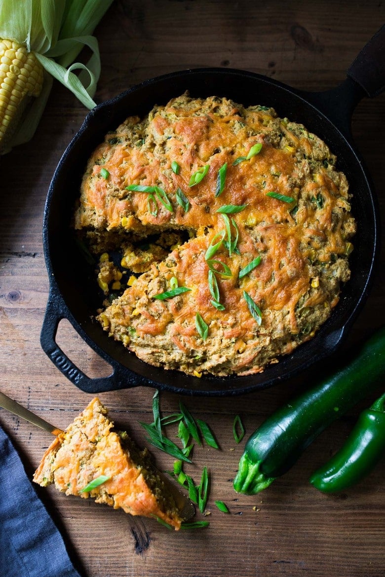 Zucchini Cornbread! A savory zucchini bread infused with Mexican spices, cornmeal, fresh corn and sharp cheddar cheese, baked in a skillet. Familiar cozy flavors make this a huge potluck hit!  #cornbread #zuccinibread #savoryzucchinibread #mexicancornbread 