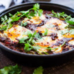 Moroccan Eggs! Eggs are baked in a flavorful lamb stew infused with Moroccan Spices, topped with Harissa Yogurt. A delicious breakfast or brunch recipe. #moroccanrecipes #bakedeggs #lambrecipes #groundlamb #brunch #breakfastrecipes