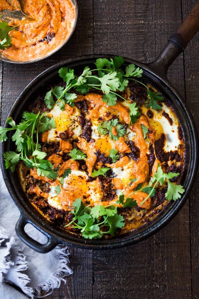 Moroccan Eggs! Eggs are baked in a flavorful lamb stew infused with Moroccan Spices, topped with Harissa Yogurt. A delicious breakfast or brunch recipe. #moroccanrecipes #bakedeggs #lambrecipes #groundlamb #brunch #breakfastrecipes 