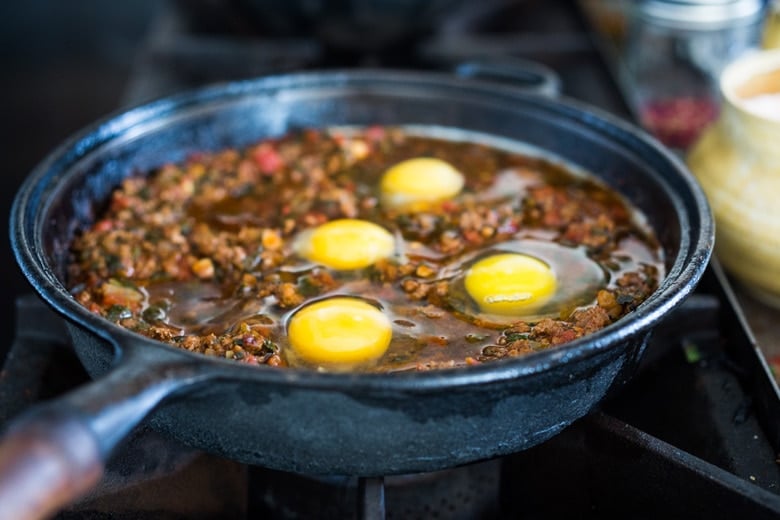 Moroccan Eggs! Eggs are baked in a flavorful lamb stew infused with Moroccan Spices, topped with Harissa Yogurt. A delicious breakfast or brunch recipe. #moroccanrecipes #bakedeggs #lambrecipes #groundlamb #brunch #breakfastrecipes 