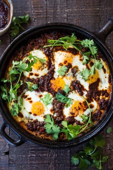 Moroccan Eggs! Eggs are baked in a flavorful lamb stew infused with Moroccan Spices, topped with Harissa Yogurt. A delicious breakfast or brunch recipe. #moroccanrecipes #bakedeggs #lambrecipes #groundlamb #brunch #breakfastrecipes