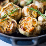 How to Roast Garlic in the oven (using whole heads of garlic or peeled garlic cloves). Roasting garlic transforms it! Spreadable, buttery, sweet, earthy, and complex it has a multitude of uses in the kitchen! And so many health benefits! Whole cloves can be stored in olive oil in the fridge for up to 10 days, or made into a paste, to add to soups, stews, sauces, dressings and mashes. #roastedgarlic #bakedgarlic #garlic #garlicbenefits #roastgarlic