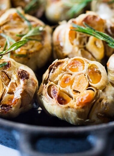 How to Roast Garlic in the oven (using whole heads of garlic or peeled garlic cloves). Roasting garlic transforms it! Spreadable, buttery, sweet, earthy, and complex it has a multitude of uses in the kitchen! And so many health benefits! Whole cloves can be stored in olive oil in the fridge for up to 10 days, or made into a paste, to add to soups, stews, sauces, dressings and mashes. #roastedgarlic #bakedgarlic #garlic #garlicbenefits #roastgarlic