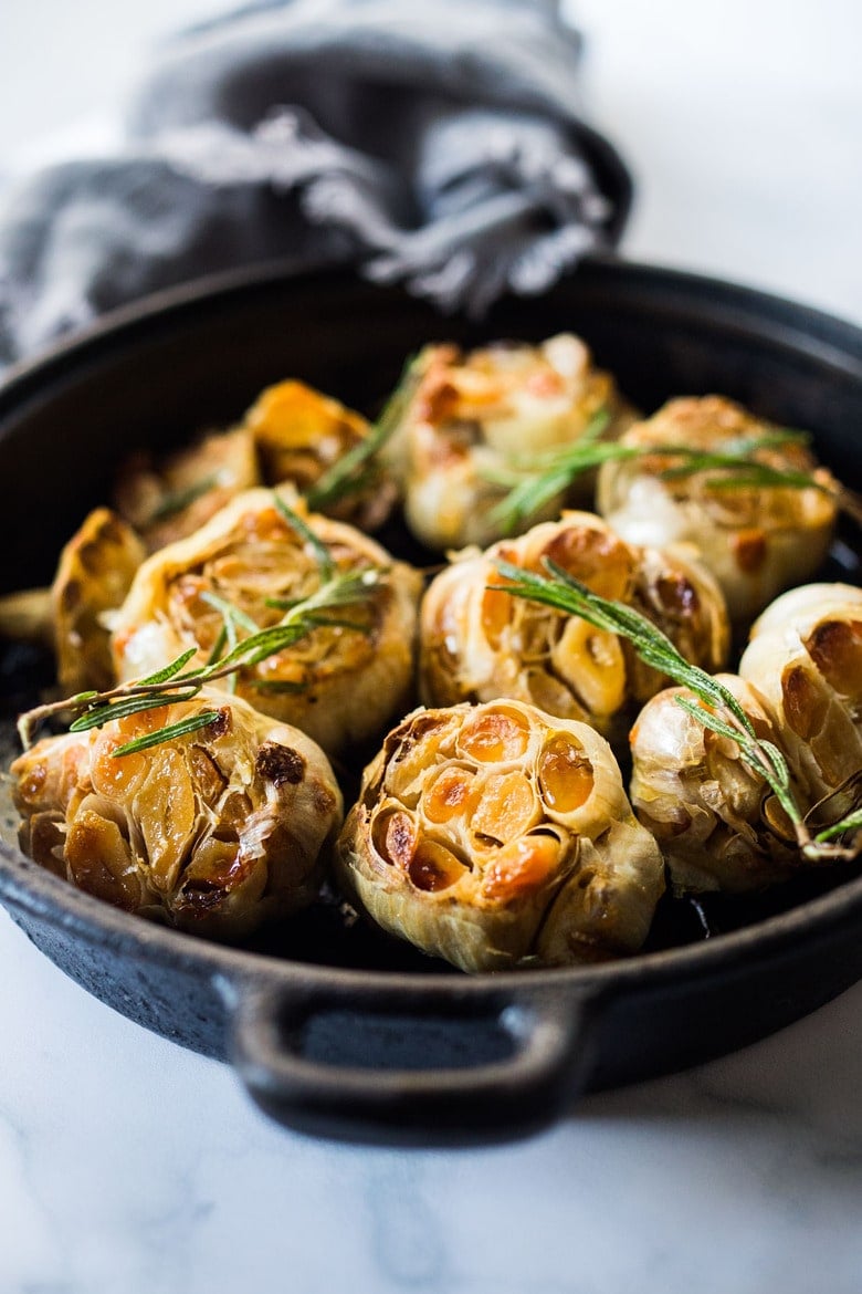 This oven roasted garlic recipe is easy to make and results in the most tender, caramelized, creamy, golden garlic cloves. Add to soups, mashed potatoes, and more! Video.